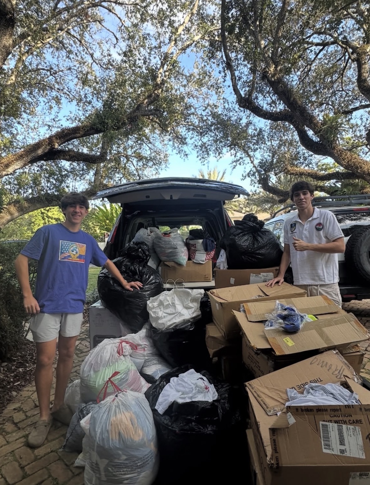 Founders loading bags and boxes of donations into a vehicle