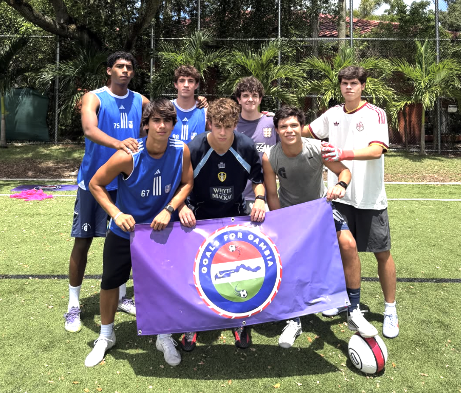 Team holding Goals For Gambia banner