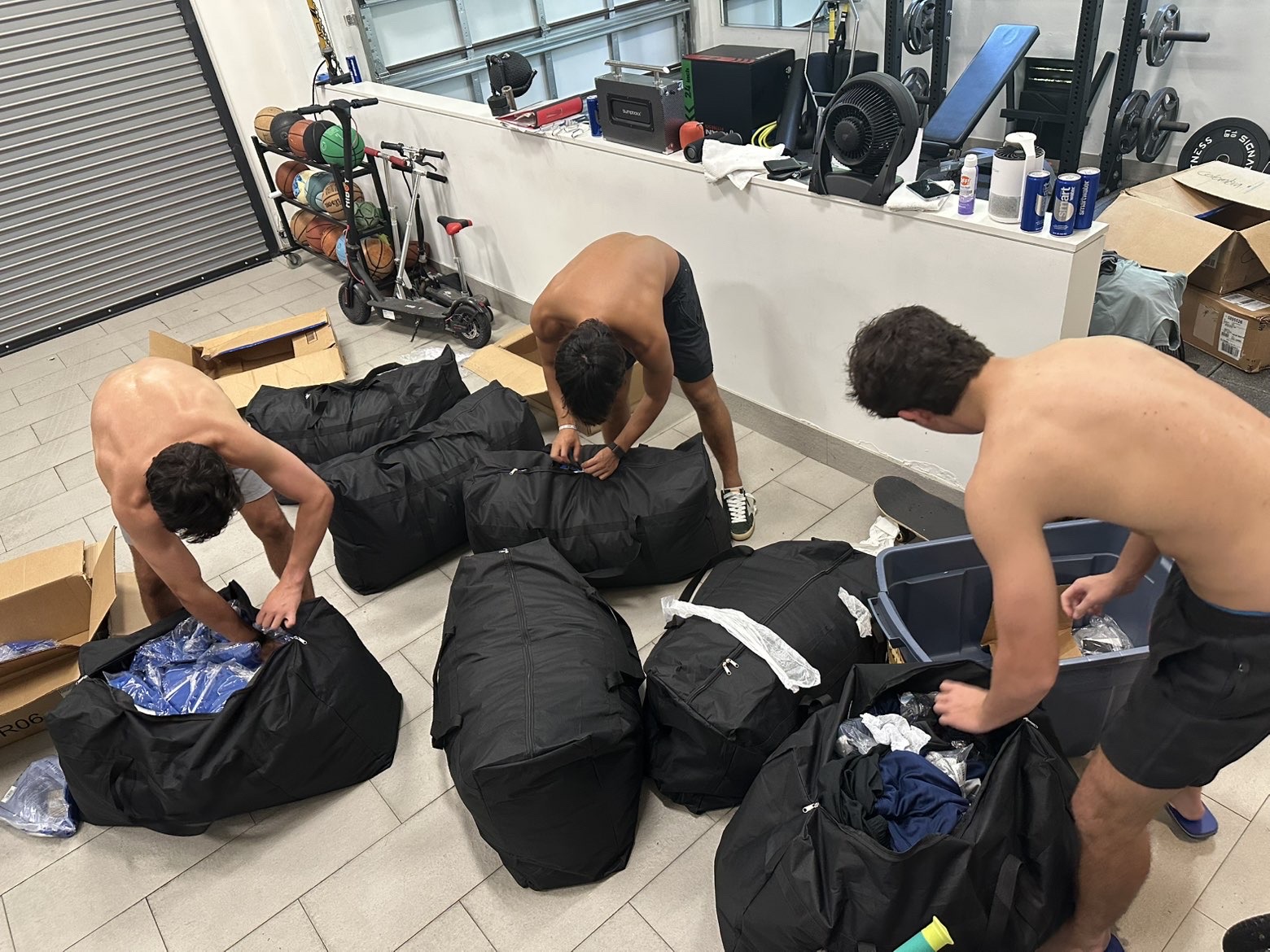 Volunteers packing clothing into large duffel bags
